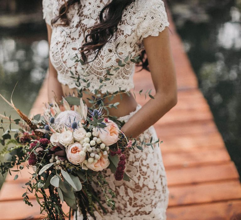 Bride wears feather bridal crown complete with short sleeved fitted lace bridal separate 