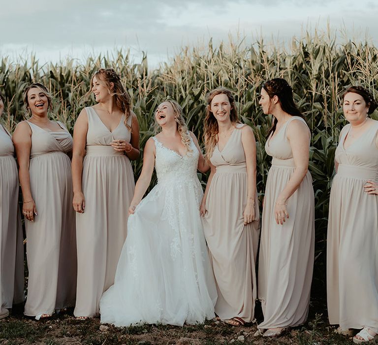 Bride stands with her bridesmaids in dusty pink bridesmaid dresses 