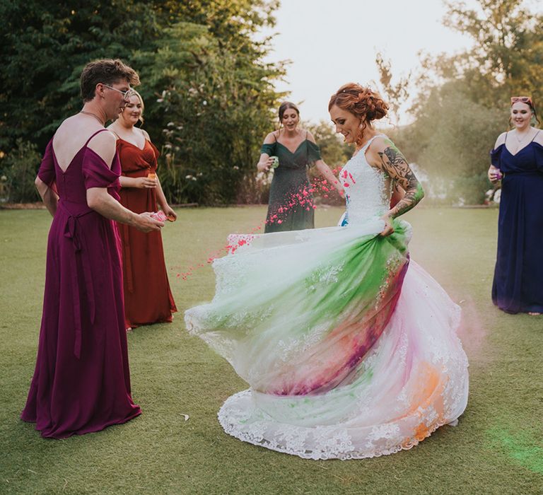 I do crew throwing colourful holi powder over the bride's lace wedding dress