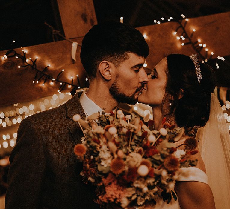 The bride and groom share a passionate kiss together on their wedding day in Devon 