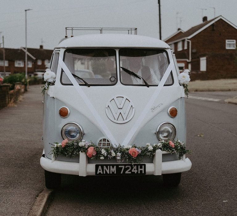 VW camper van wedding car transportation decorated with white ribbon and pink flower decor 