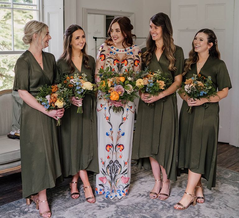 Bride in colourful Temperley Bridal wedding dress with bridal party in dark green wrap bridesmaid dresses 