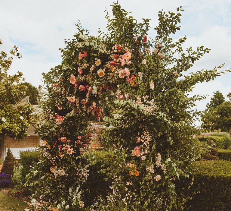 Pink, orange and white wedding floral arch altar decoration for outdoor wedding at the Four Seasons 