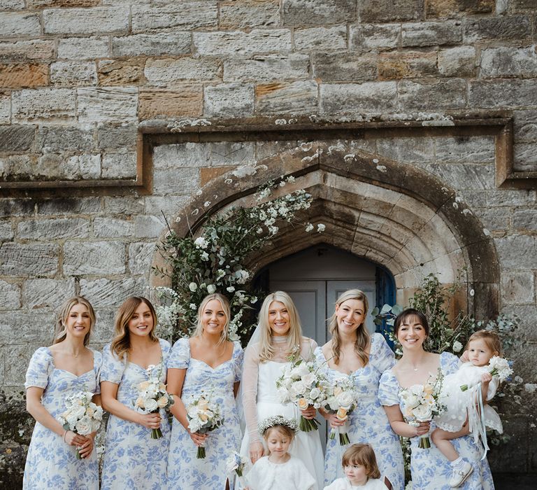 Bridal party with flower girls posing together for group photo 