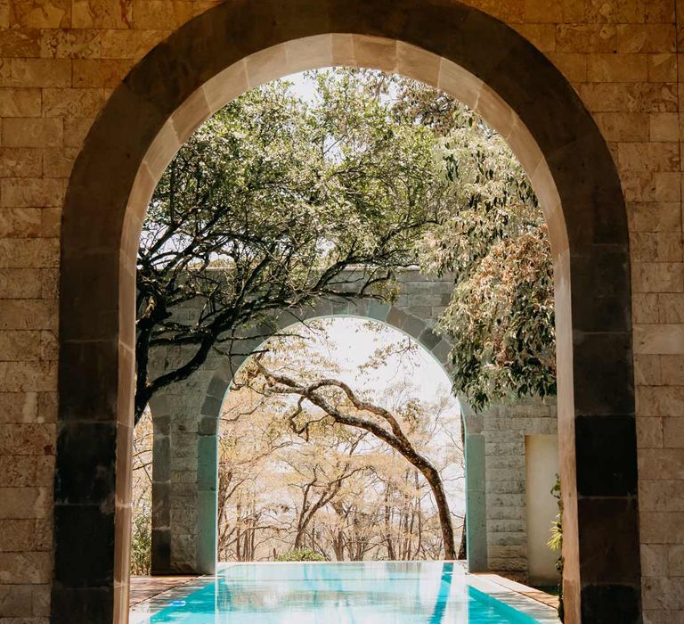 Swimming pool through the archways at Giraffe Manor wedding venue Kenya 