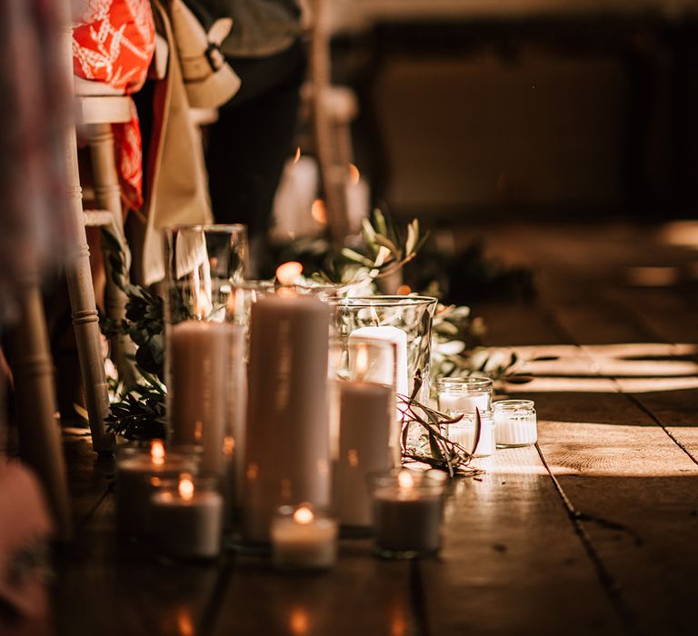 Romantic tea lights and pillar candles decorating the wedding aisle at Elmore Court in Gloucester 