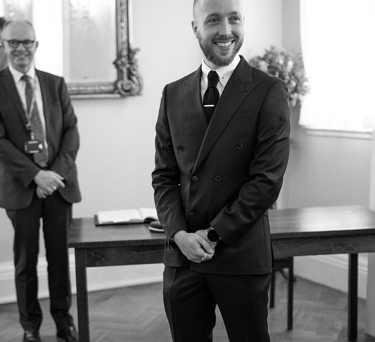 Groom standing at the altar in a black suit of registry office wedding in London 