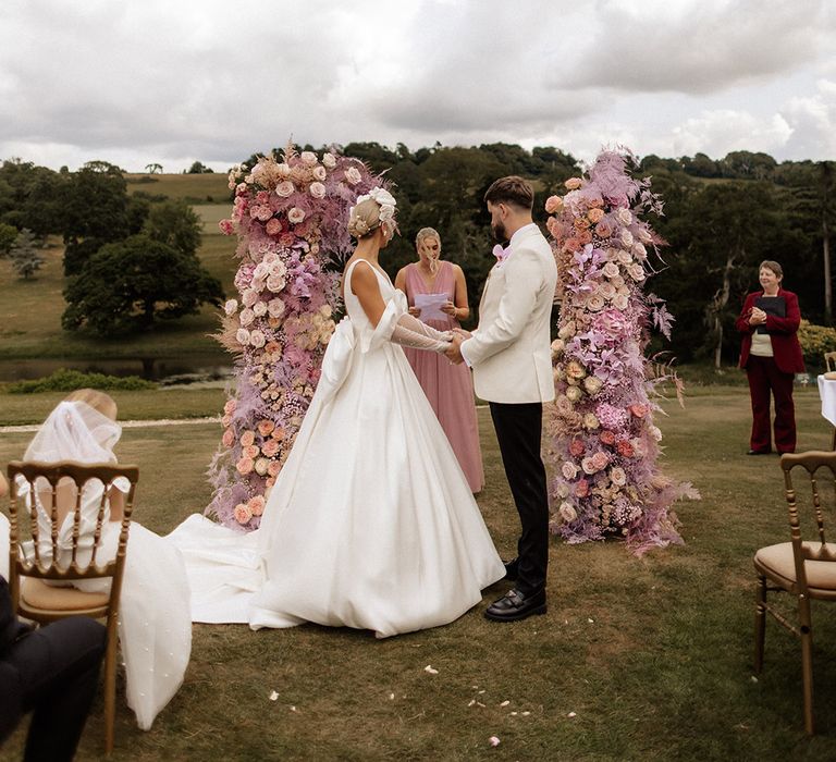 Pink flower column decorations at outdoor wedding ceremony at Minterne House wedding venue 