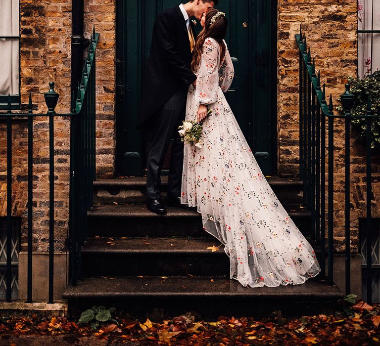 The bride and groom share a kiss in front of London townhouse 