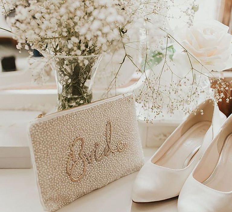 Image of bridal clutch bag with embellished "Bride" resting on the table by Steph Newton Photography