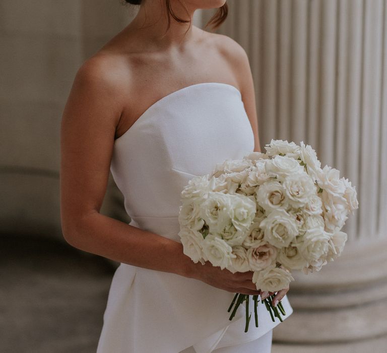 Bride in Roland Mouret wedding dress holding an all white wedding bouquet 