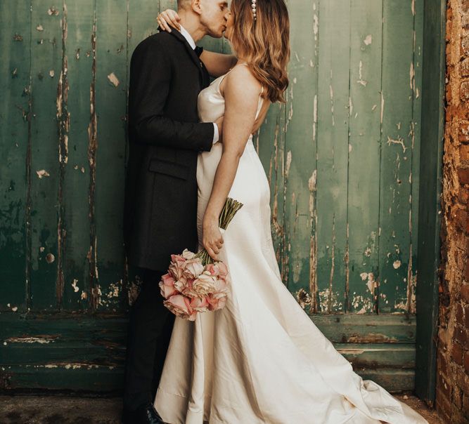 March Wedding bride and groom kissing at countryside wedding