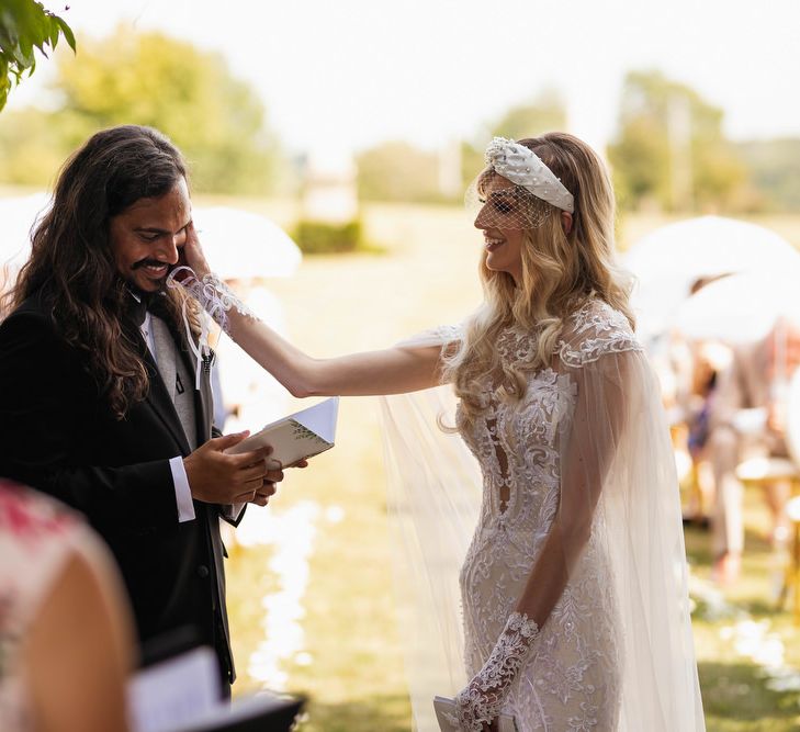 Bride touching her grooms face during the wedding vows 