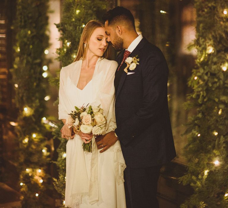 December Wedding in London with bride and groom with Christmas lights 