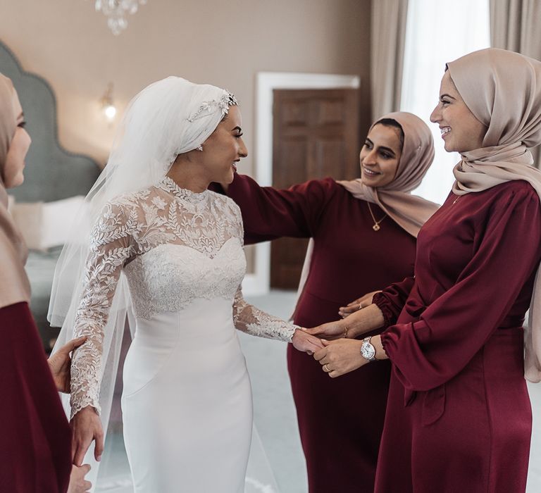 Bride with her bridesmaids in maroon dresses on the wedding morning 