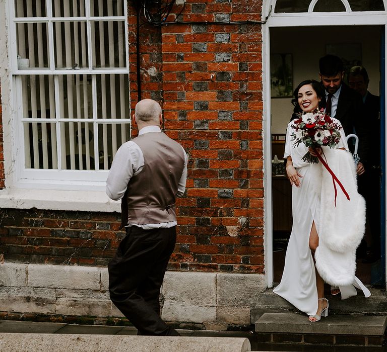 Bride with red and white rose bouquet and wedding hair updo