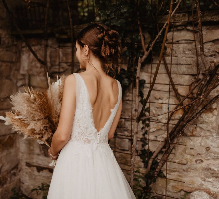 Bride in Watters wedding dress holding dried flower wedding bouquet