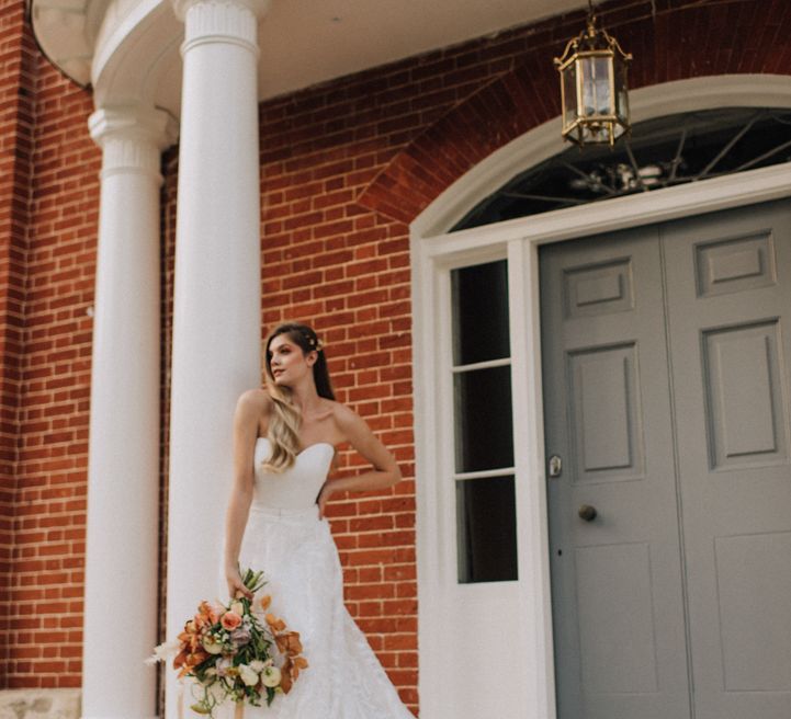 Bride holding autumn flower bouquet at Reymerston Hall