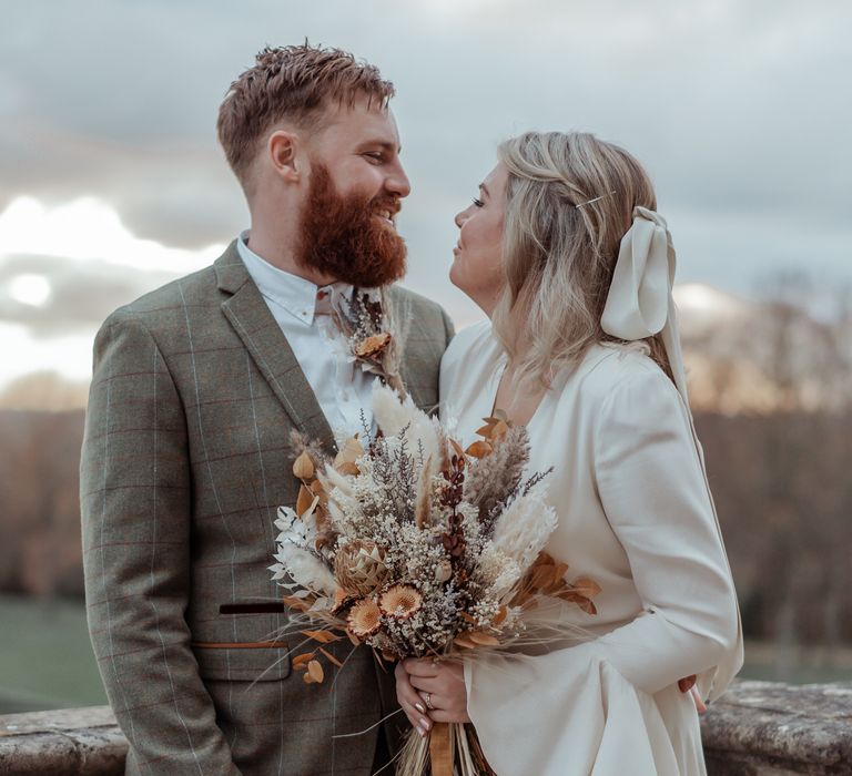 Bride & groom look lovingly at one another on wedding day