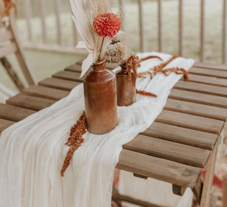 Flowers in brass vases on white table cloth