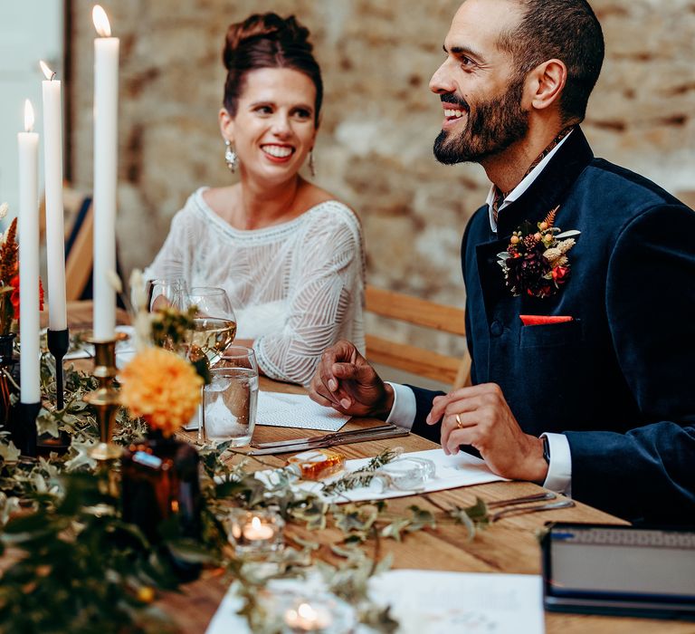 Bride & groom laugh together during wedding reception 