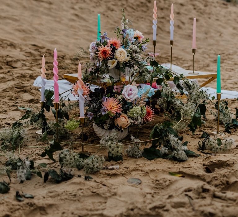 Pastel coloured wedding flowers and candles at intimate beach elopement picnic table 