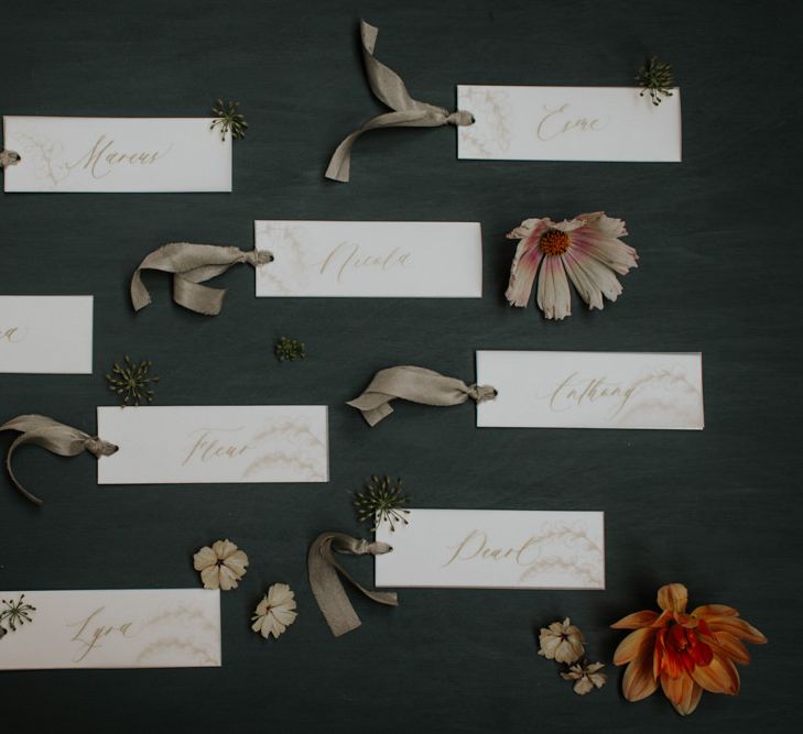 White and gold wedding name cards with ribbon detailing