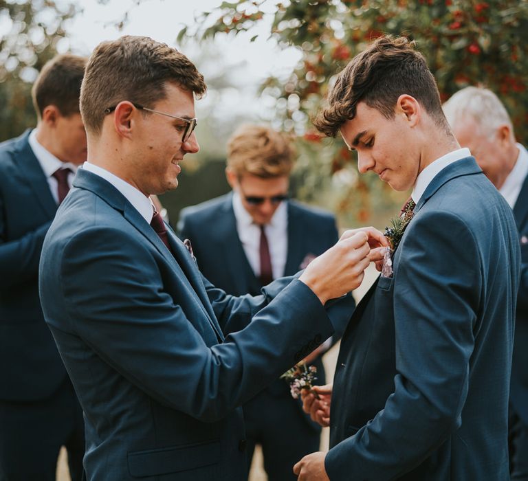 Groom fixes pocket square of a Groomsmen 