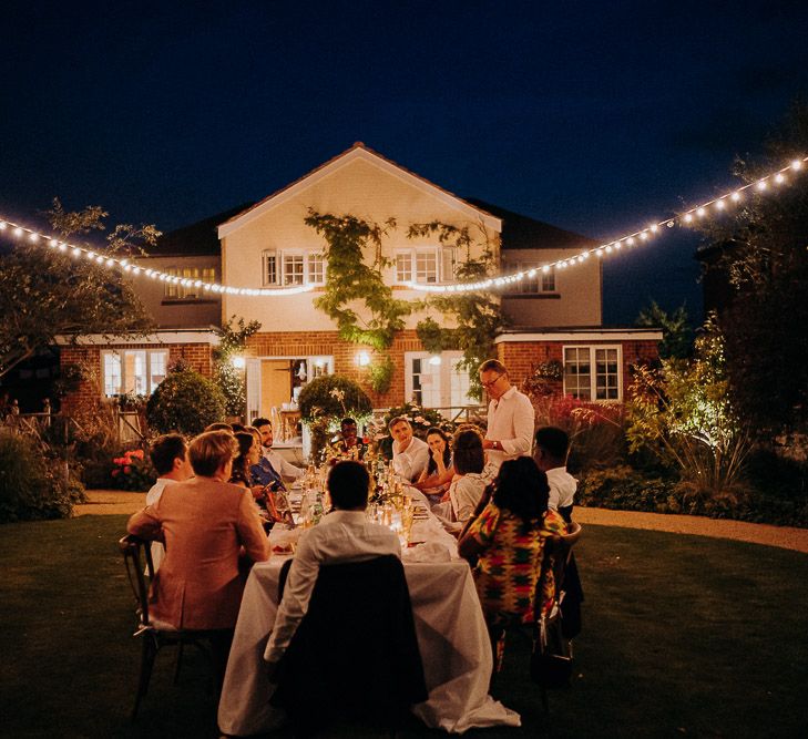 Festoon lights hanging in the garden of the intimate wedding reception 