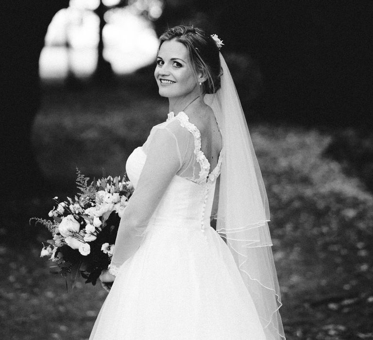 Black & white image of bride wearing long sleeve wedding gown 