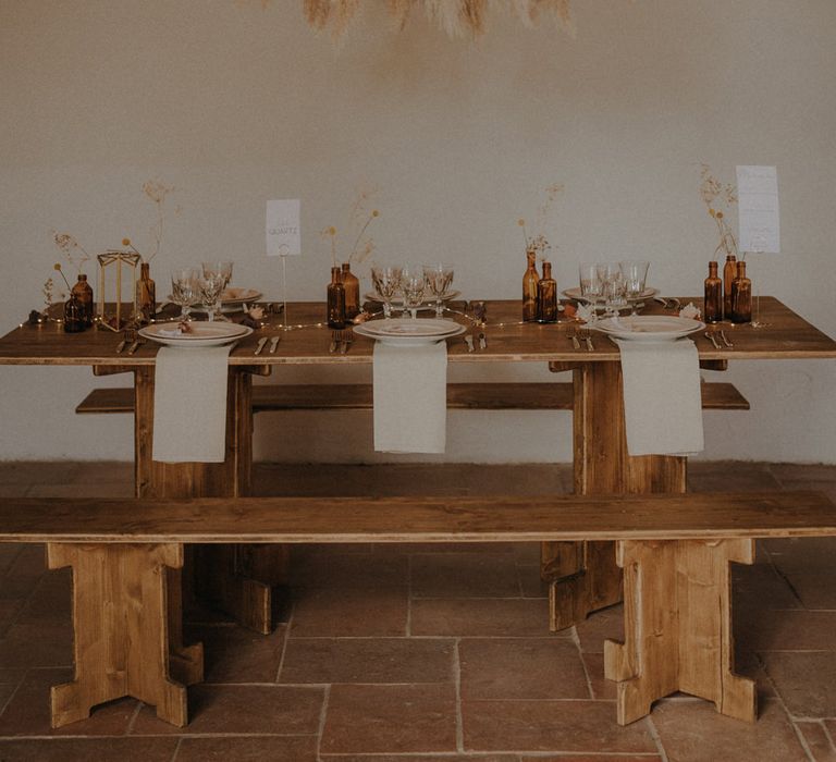 Minimalist wedding reception with wooden table and pampas grass installation