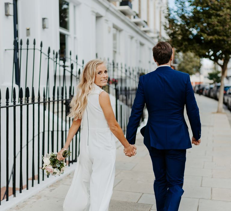 Bride & groom walk hand in hand through London