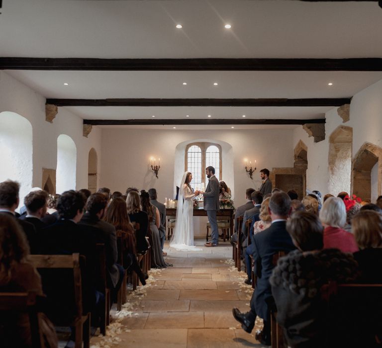 Bride and groom standing at alter with a view of the guests at Brympton House