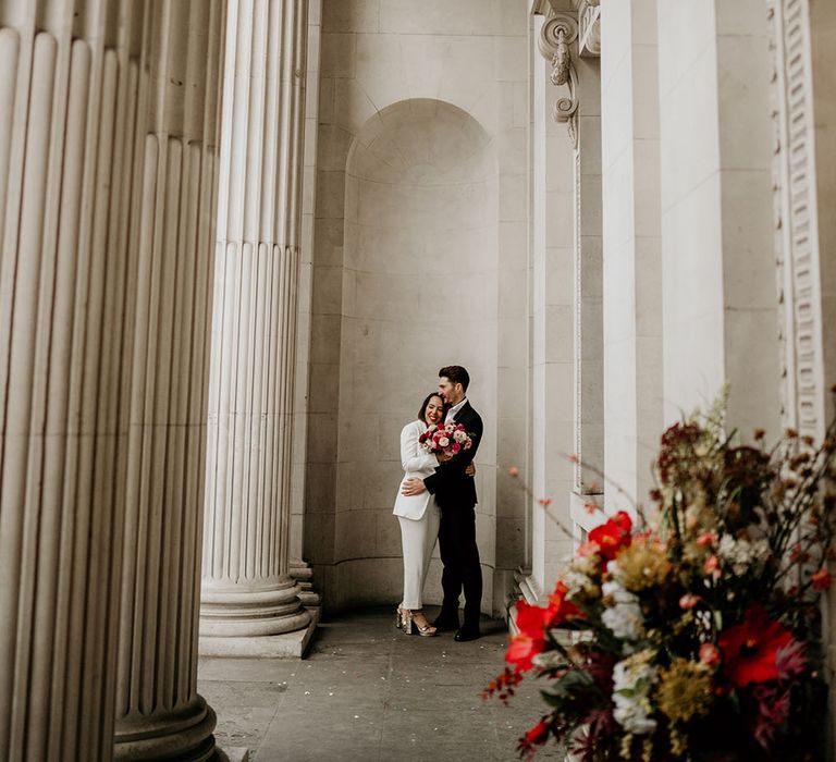 Bride & groom embrace under the Old Marylebone Town Hall 