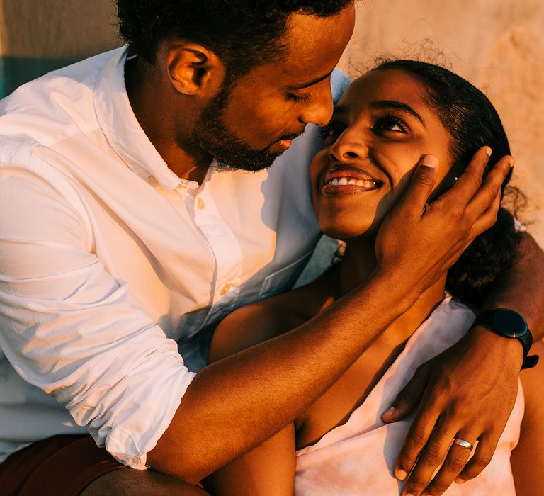 Groom caresses brides face as they look lovingly at one another