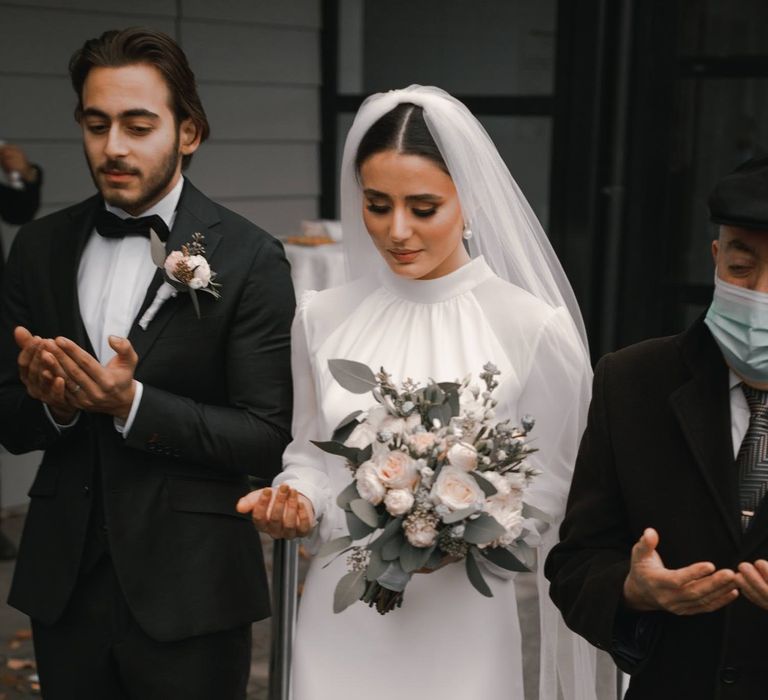 Bride & groom stand together on the day of their wedding