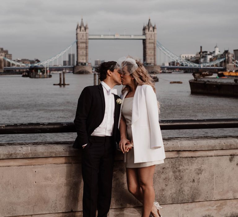 Bride and groom kissing overlooking London - bride wears short wedding dress 