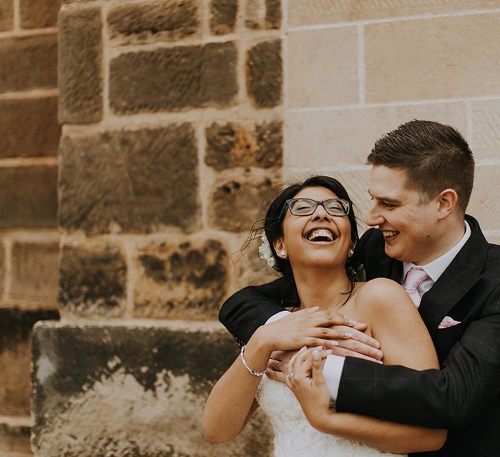 A bride and grooms hug for wedding portrait.