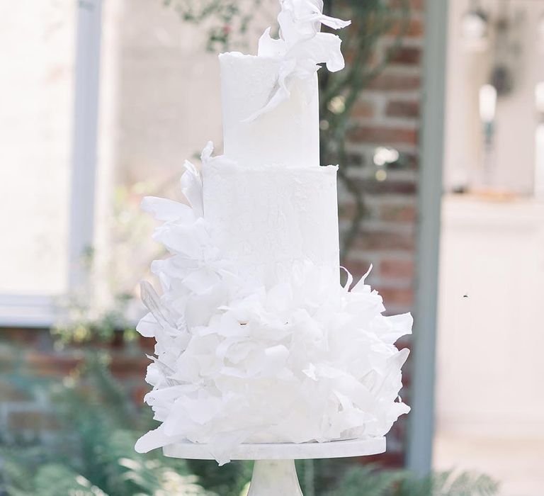 Tall white wedding cake with ruffle design by Where The Ribbon Ends