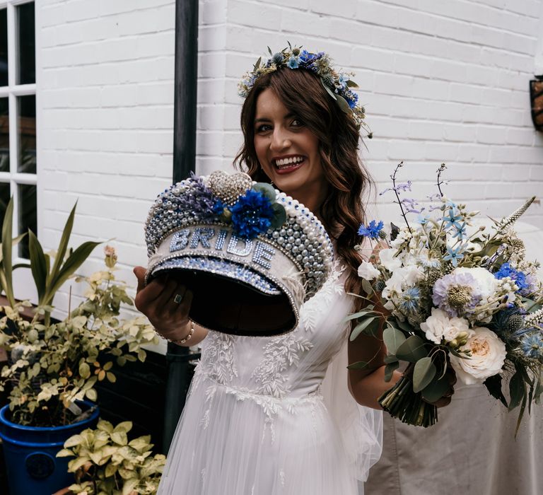 Bride holds out her jewelled bridal hat for wedding reception party