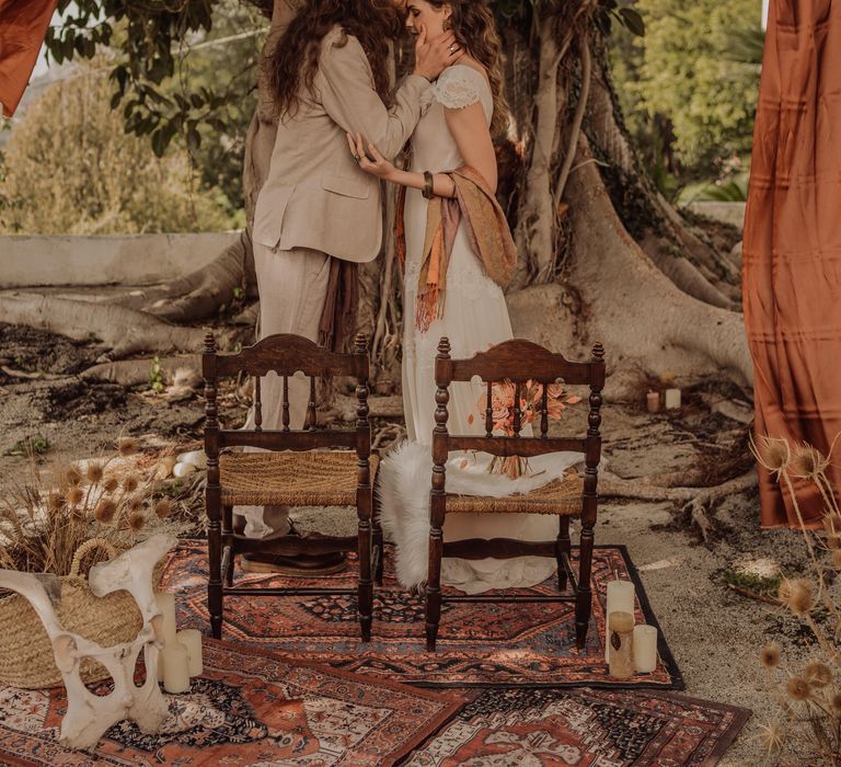 Groom with long hair kisses bride on forehead during wedding ceremony in Sicily, complete with hippie & rustic vibes