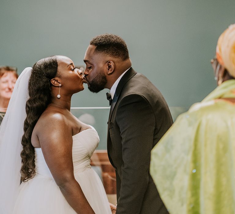 Bride & groom kiss during wedding ceremony 