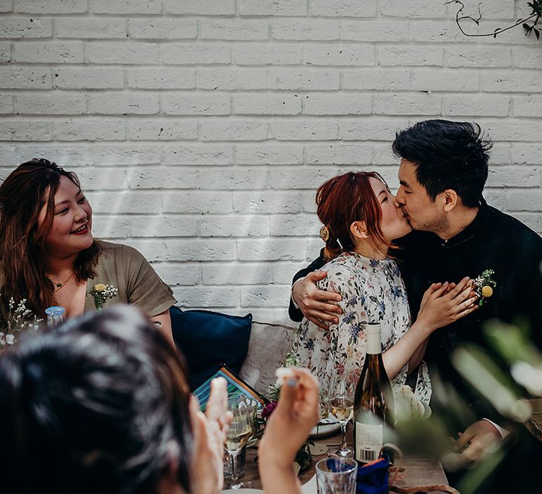 Groom kissing his bride during the intimate wedding reception at Carousel in Marylebone