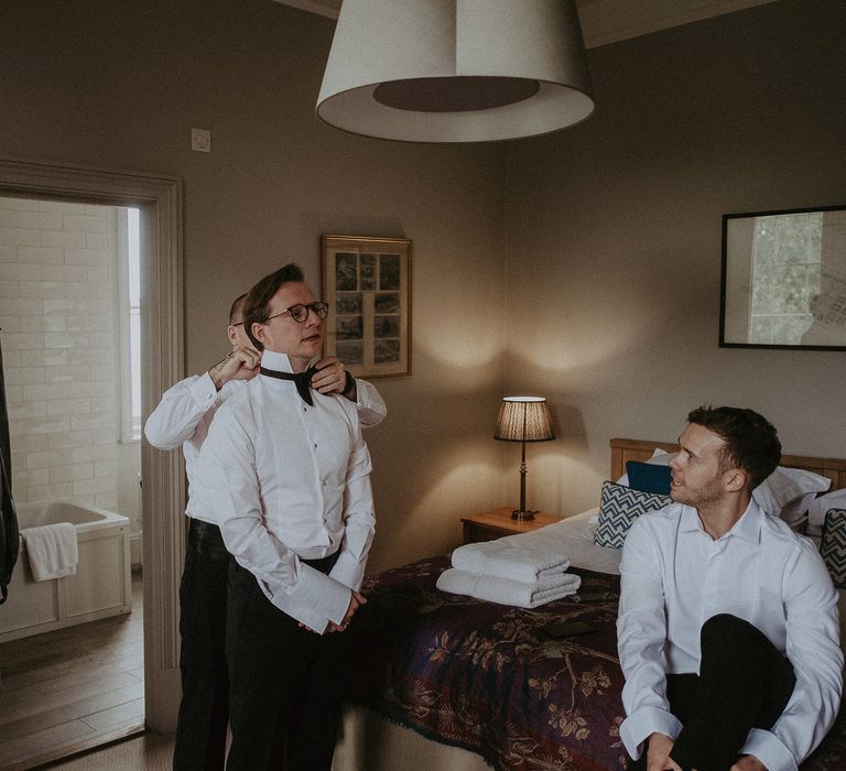 Groom gets ready on the morning of his wedding day in black tie