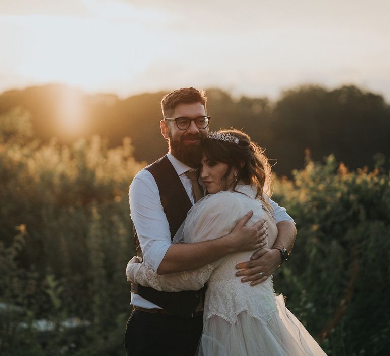 Bride & groom embrace as the sun goes down during golden hour on their wedding day