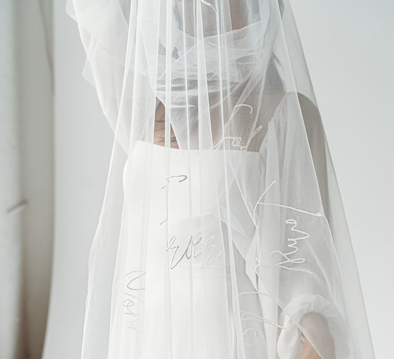 Cathedral length wedding veil with embroidered words all over it 