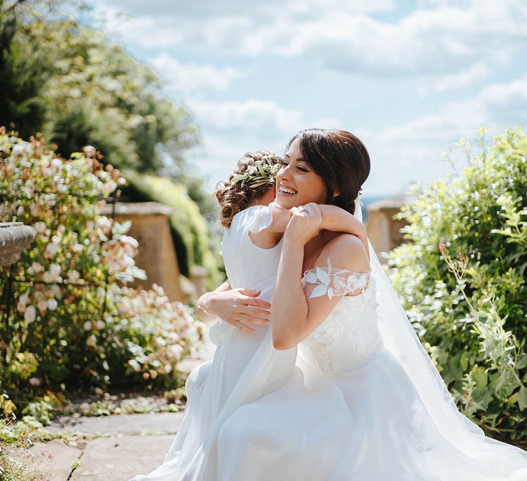 Bride hugs her flower girl on her wedding day