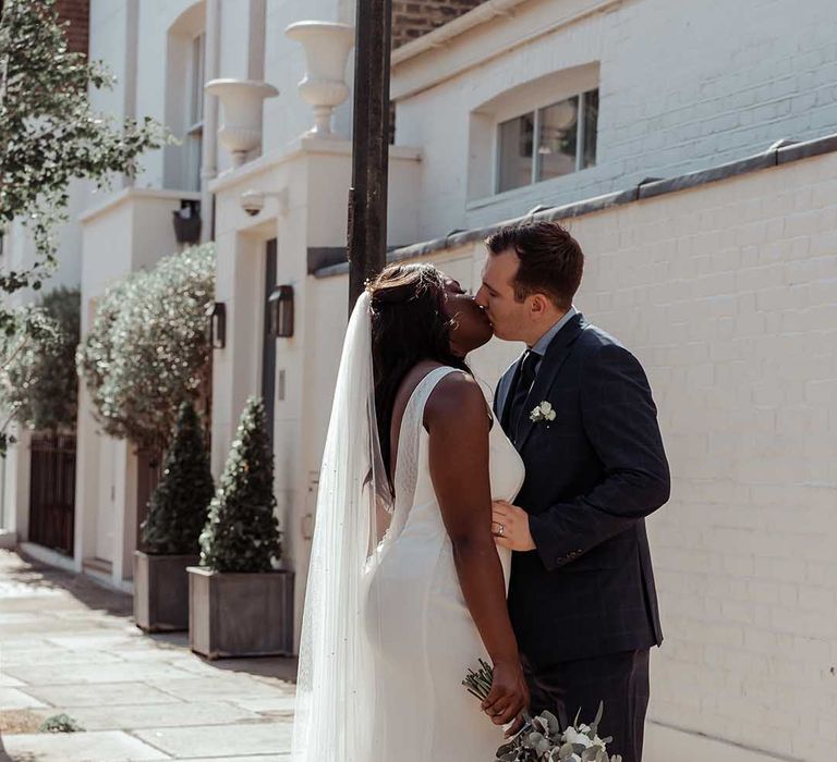 Bride & groom kiss outdoors on their wedding day in Chelsea 