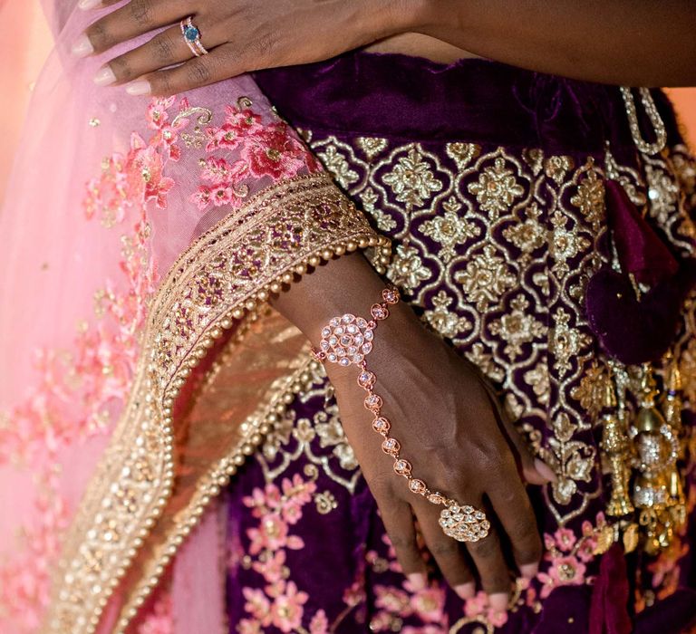 Bride wears sapphire ring surrounded by diamonds 