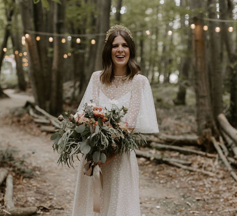 Bride stands with her bouquet outdoors on her wedding day